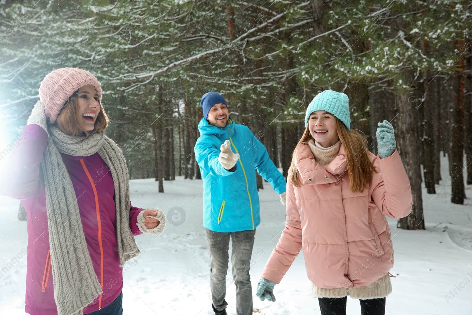 Photo of Happy family playing snowballs in winter forest