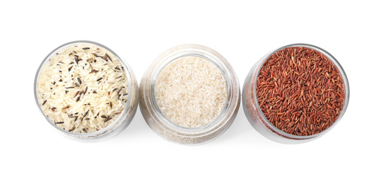 Photo of Brown and polished rice in jars isolated on white, top view