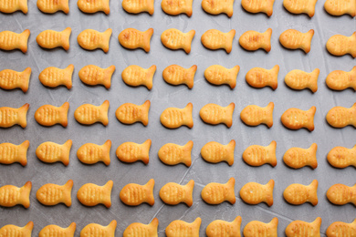 Delicious goldfish crackers on grey table, flat lay