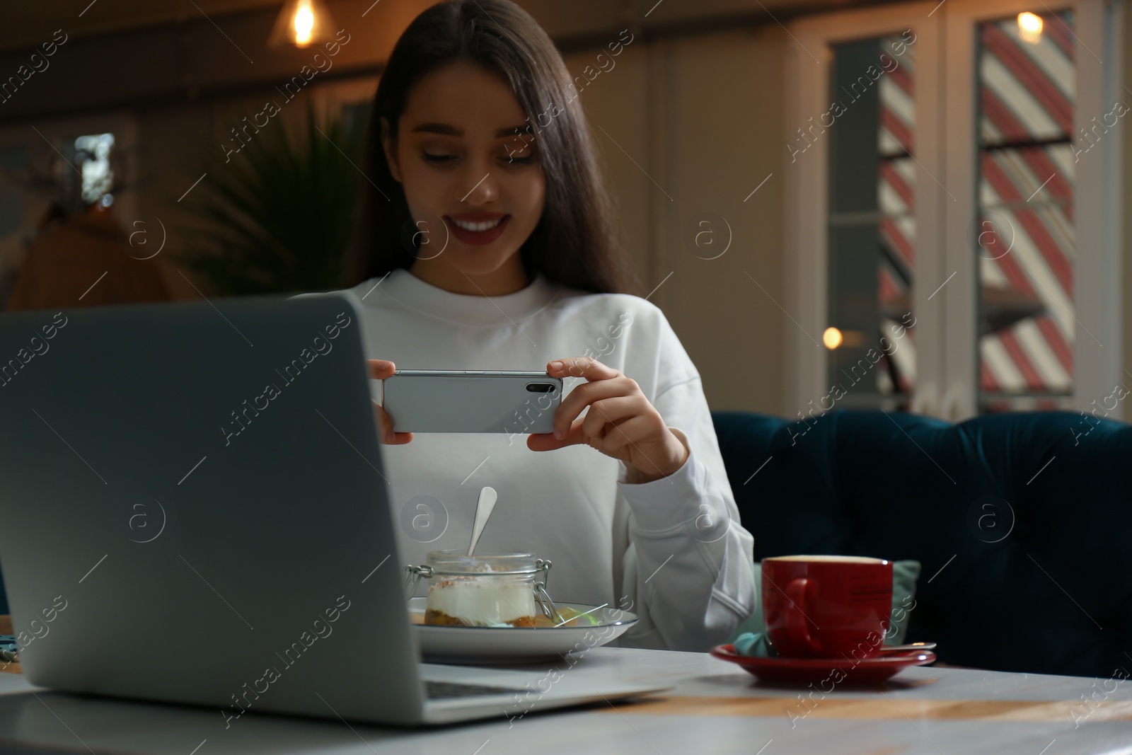 Photo of Blogger taking picture of dessert at table in cafe