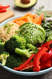 Photo of Delicious vegan bowl with bell peppers, avocados and broccoli on table, closeup