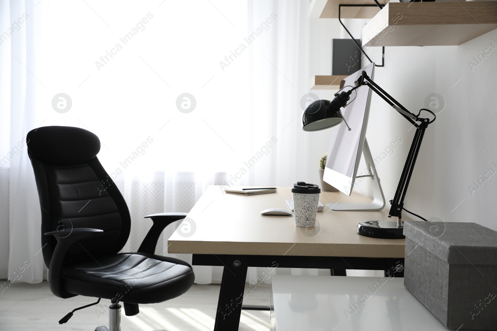 Photo of Comfortable office chair near table with modern computer