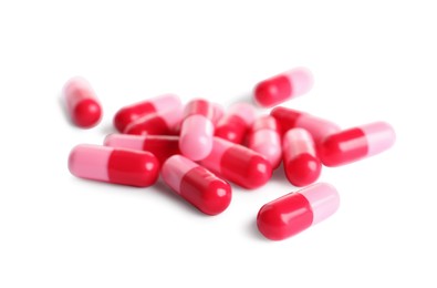 Photo of Many pink pills isolated on white. Medicinal treatment