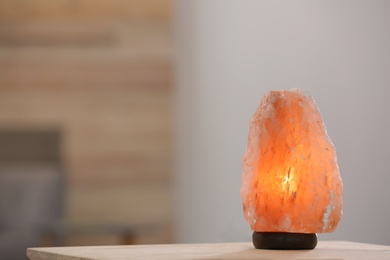 Photo of Himalayan salt lamp on table against blurred background