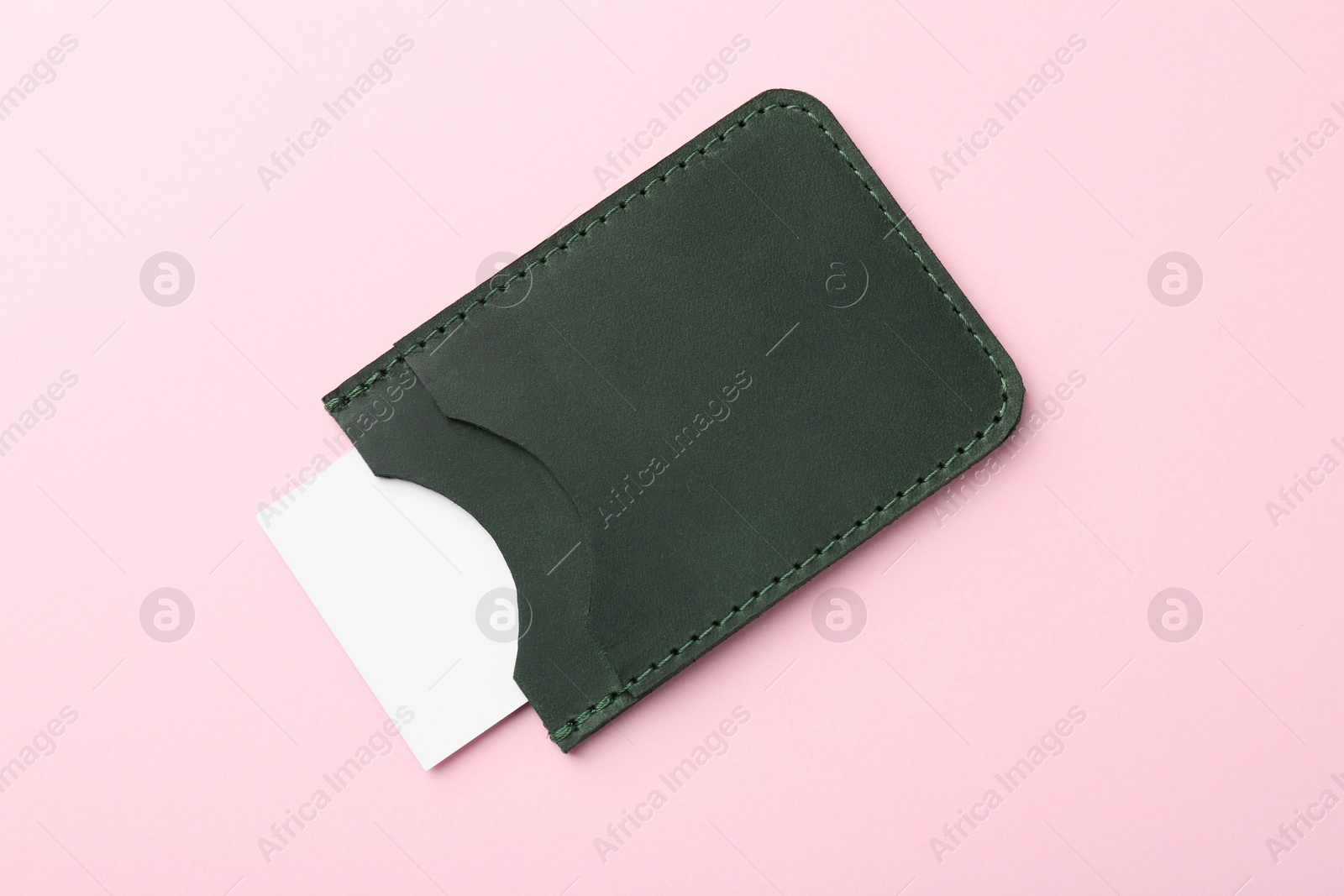 Photo of Leather business card holder with blank card on pink background, top view