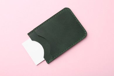 Photo of Leather business card holder with blank card on pink background, top view