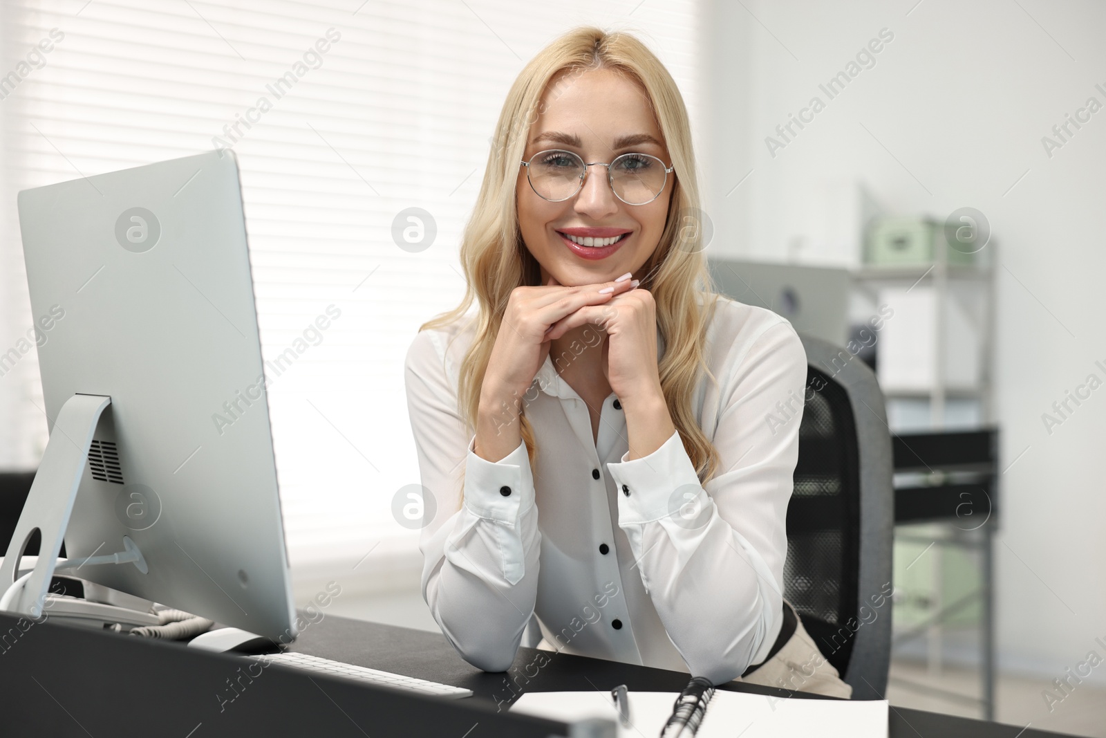 Photo of Happy secretary in glasses at table in office