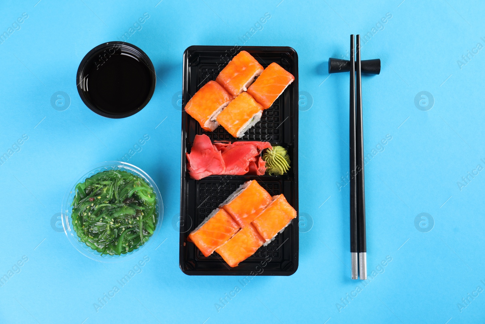 Photo of Flat lay composition with sushi rolls on color background. Food delivery