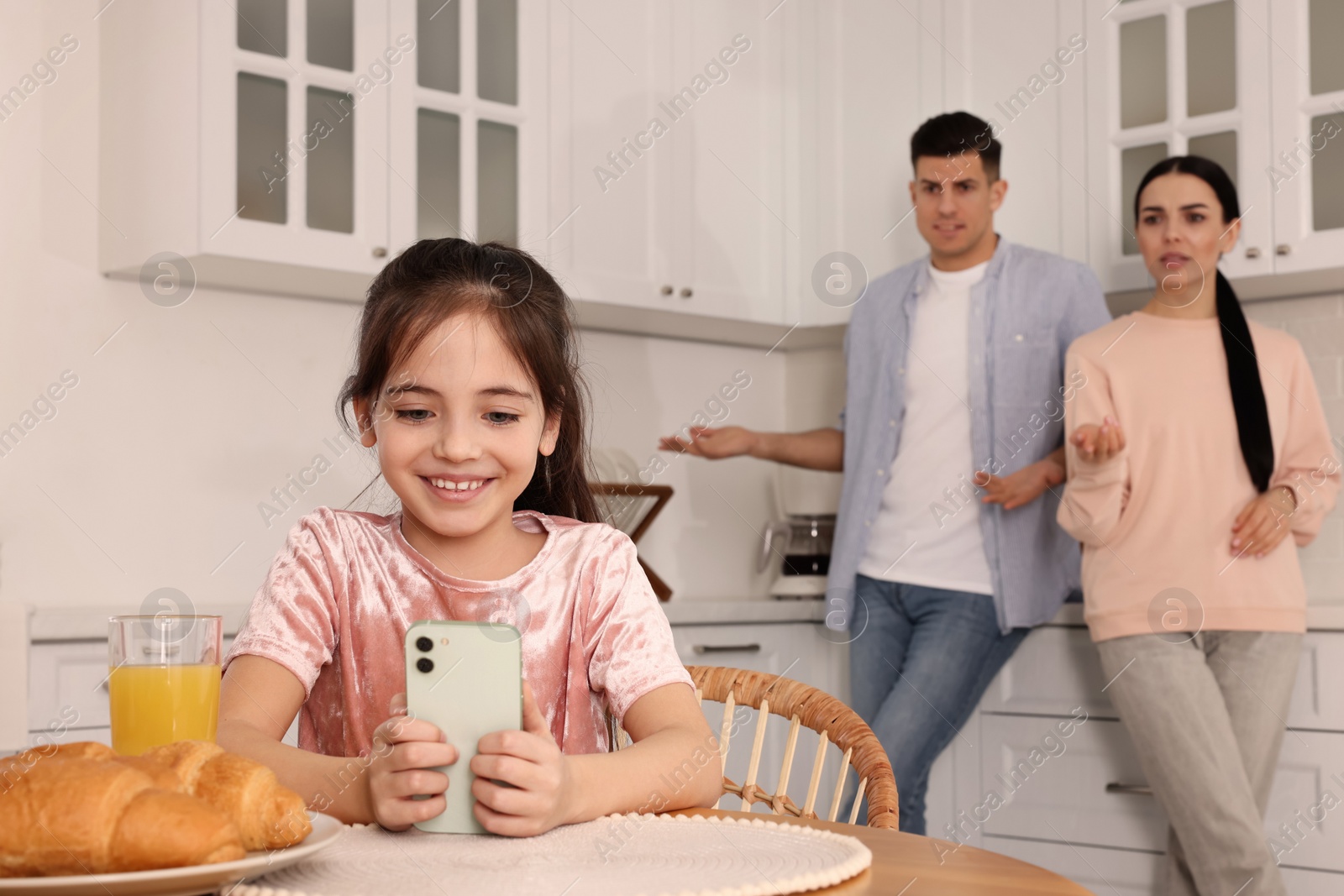 Photo of Internet addiction. Parents scolding their daughter while she using smartphone in kitchen