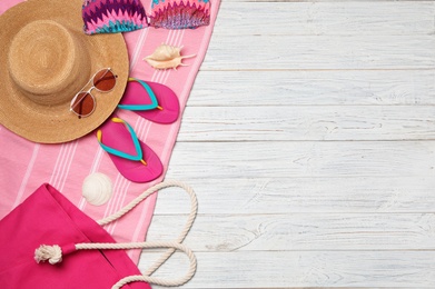 Flat lay composition with beach accessories on wooden background. Space for text