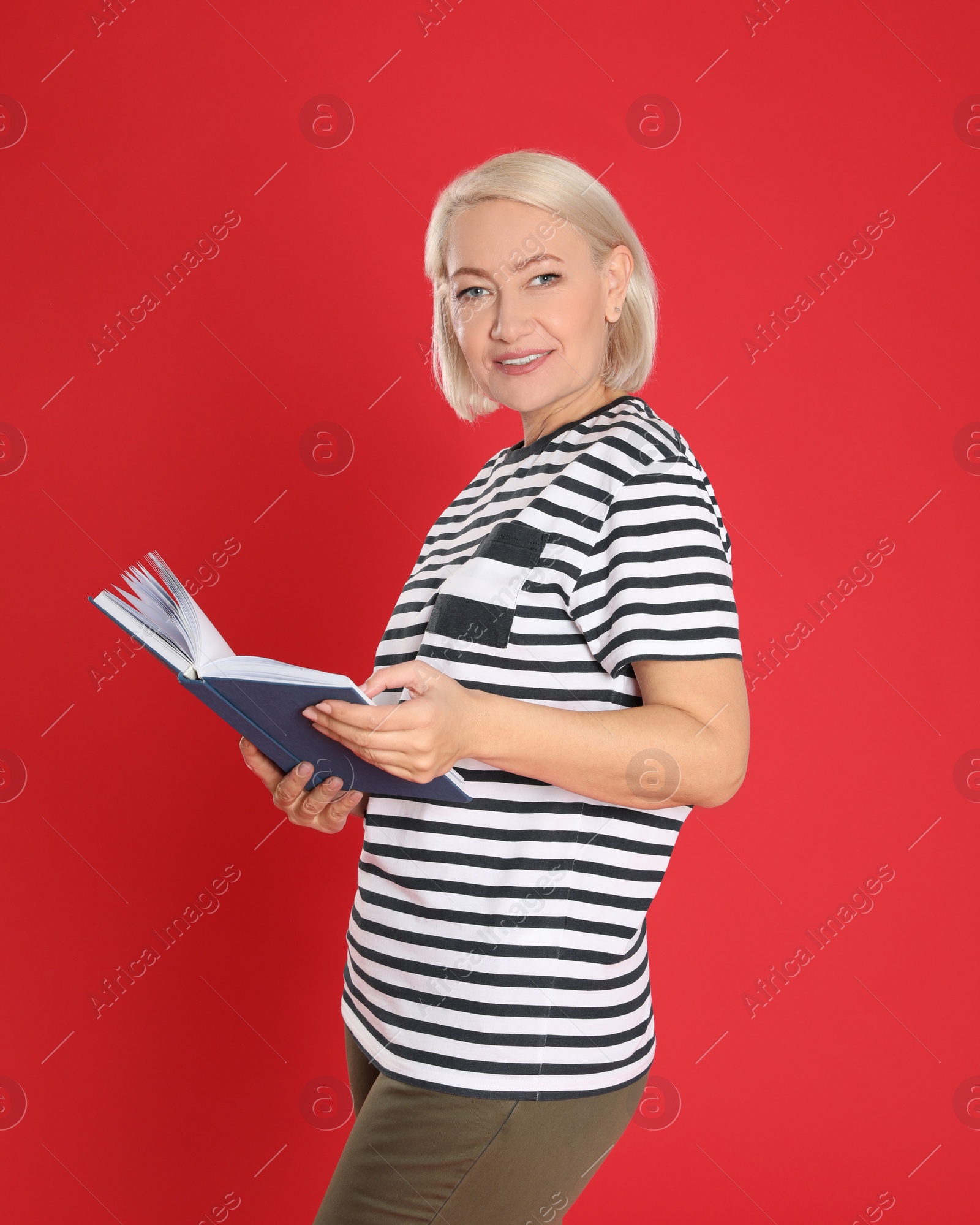 Photo of Senior woman reading book on color background