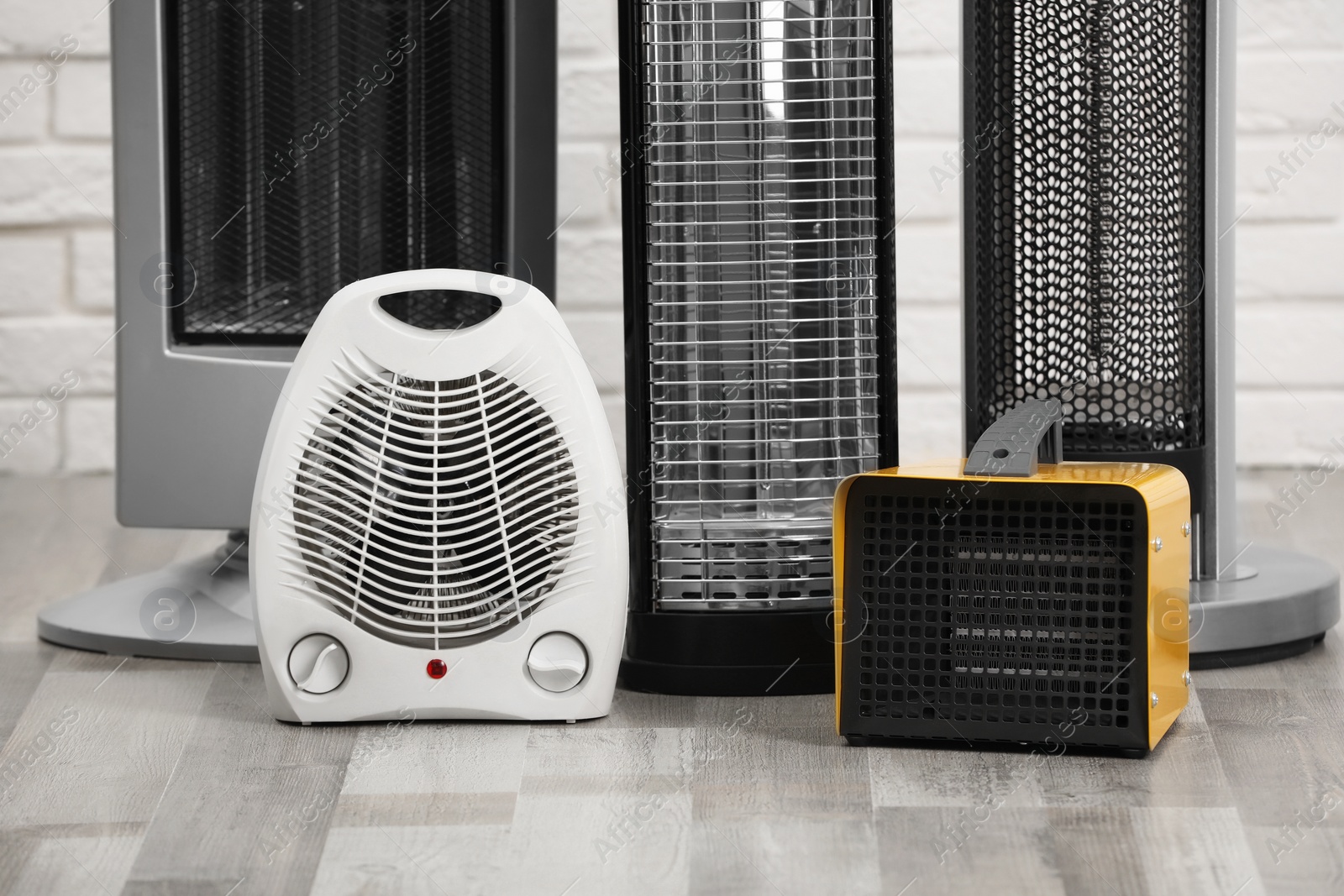 Photo of Different modern electric heaters on floor in room