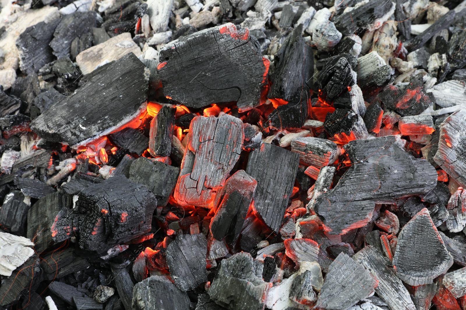 Photo of Many smoldering coals as background, closeup view