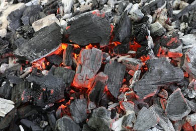 Photo of Many smoldering coals as background, closeup view