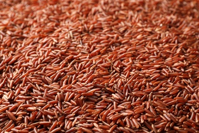 Photo of Raw brown rice as background, closeup view