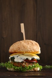 Photo of Delicious vegetarian burger served on wooden table