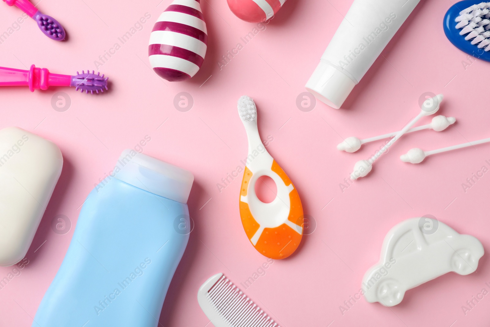 Photo of Flat lay composition with baby toothbrushes and toiletries on color background