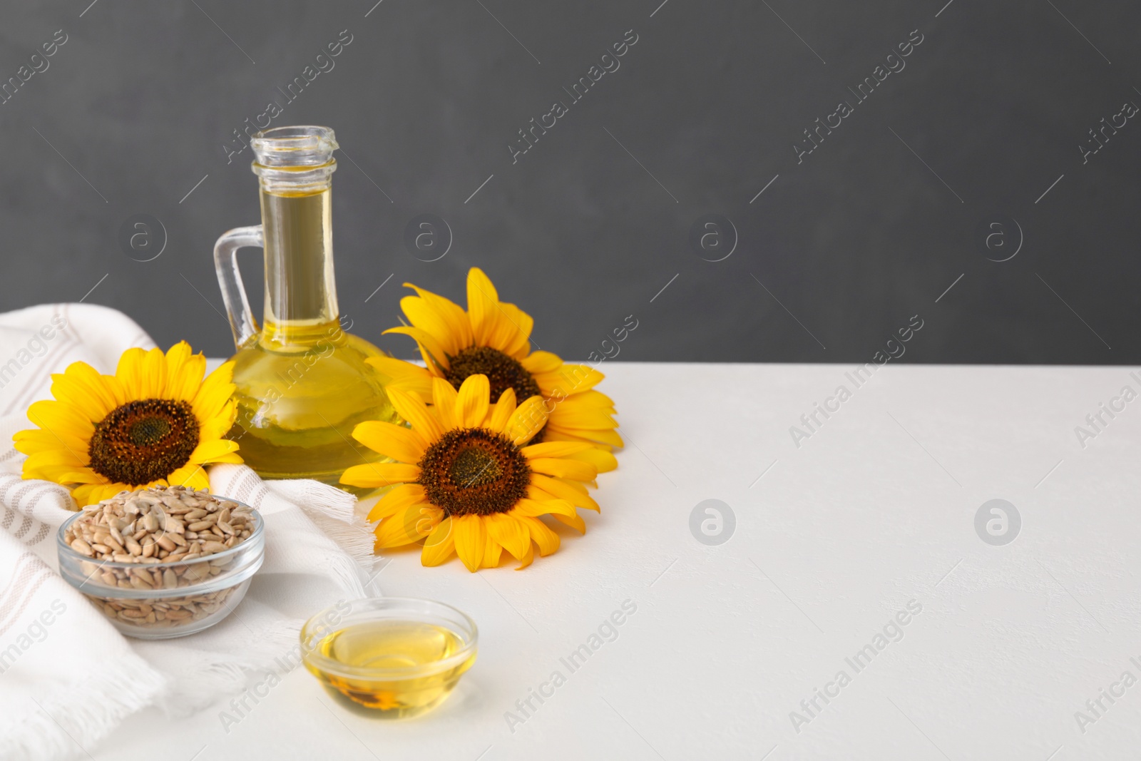 Photo of Composition with sunflower oil on white table, space for text