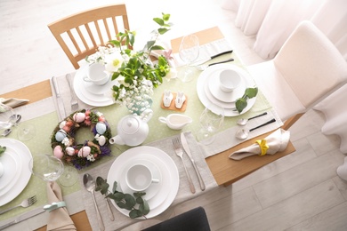 Beautiful Easter table setting with festive decor indoors, above view