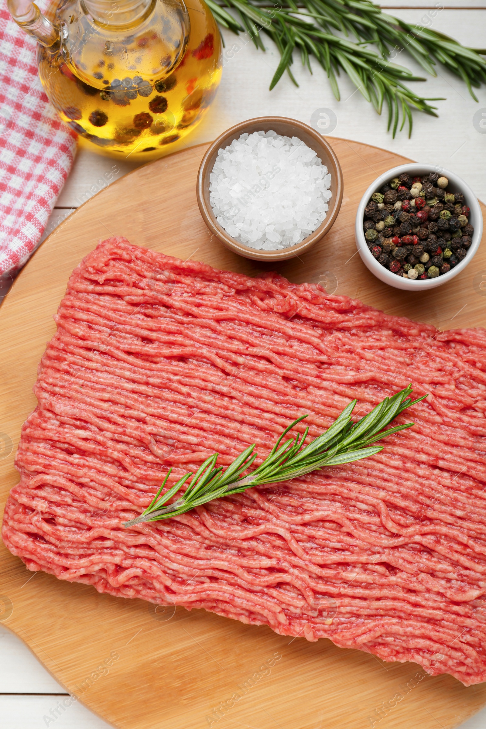 Photo of Raw fresh minced meat with rosemary and spices on white wooden table, flat lay