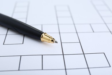 Photo of Pen and blank crossword, closeup. Space for text