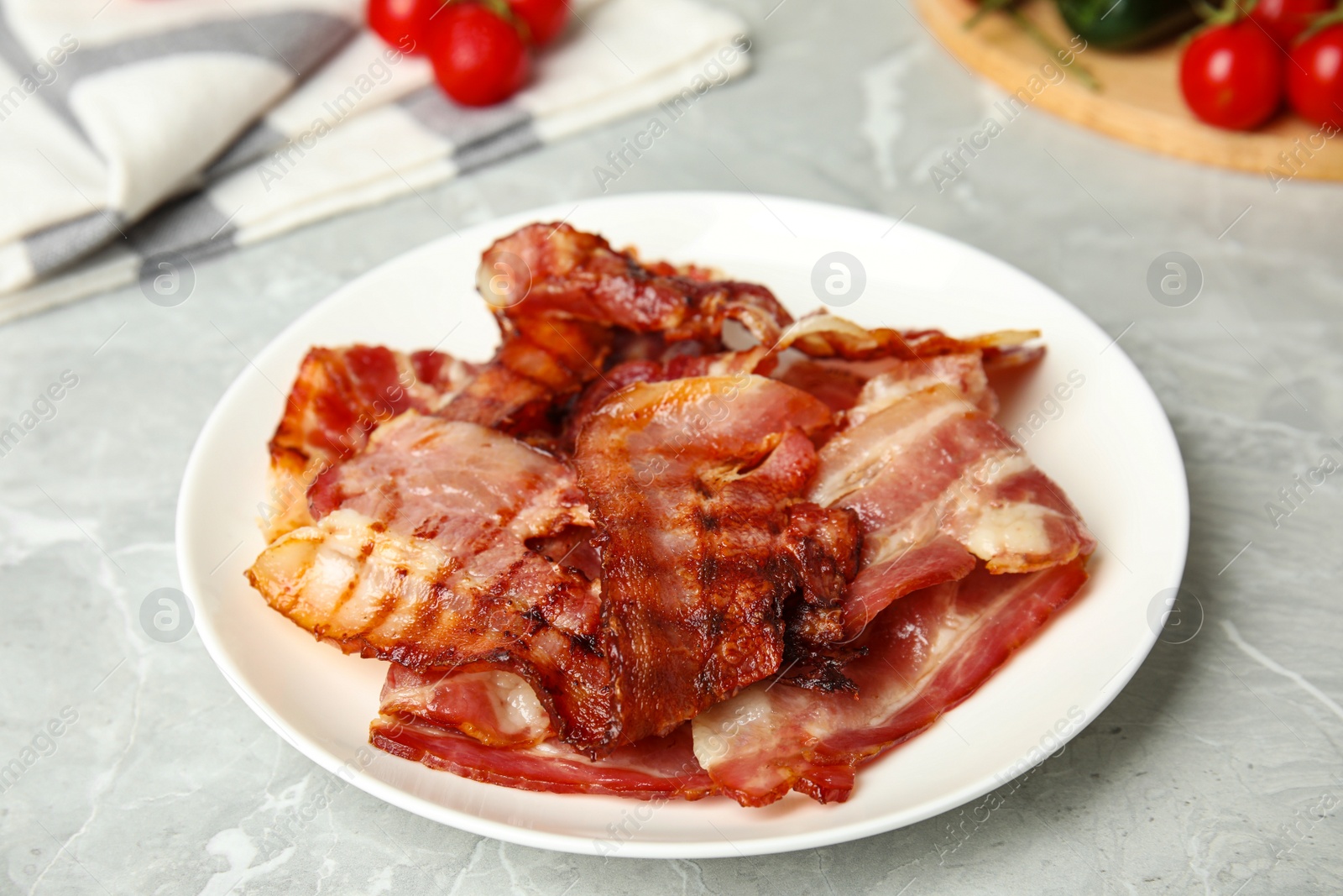 Photo of Slices of tasty fried bacon on light marble table