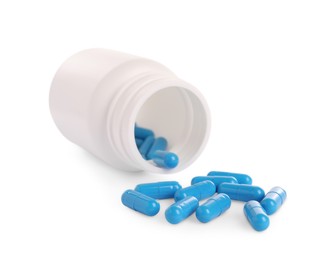 Photo of Medical bottle and blue pills on white background