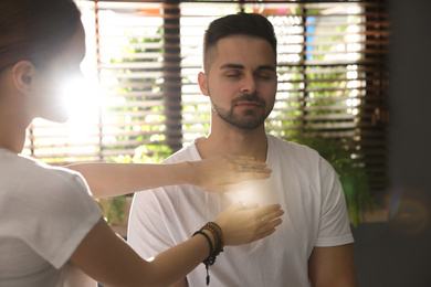 Photo of Young man during healing session in therapy room