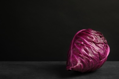 Photo of Pointed red cabbage on table against black background. Healthy food