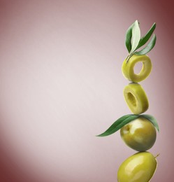 Image of Cut and whole green olives with leaves on brown gradient background, space for text