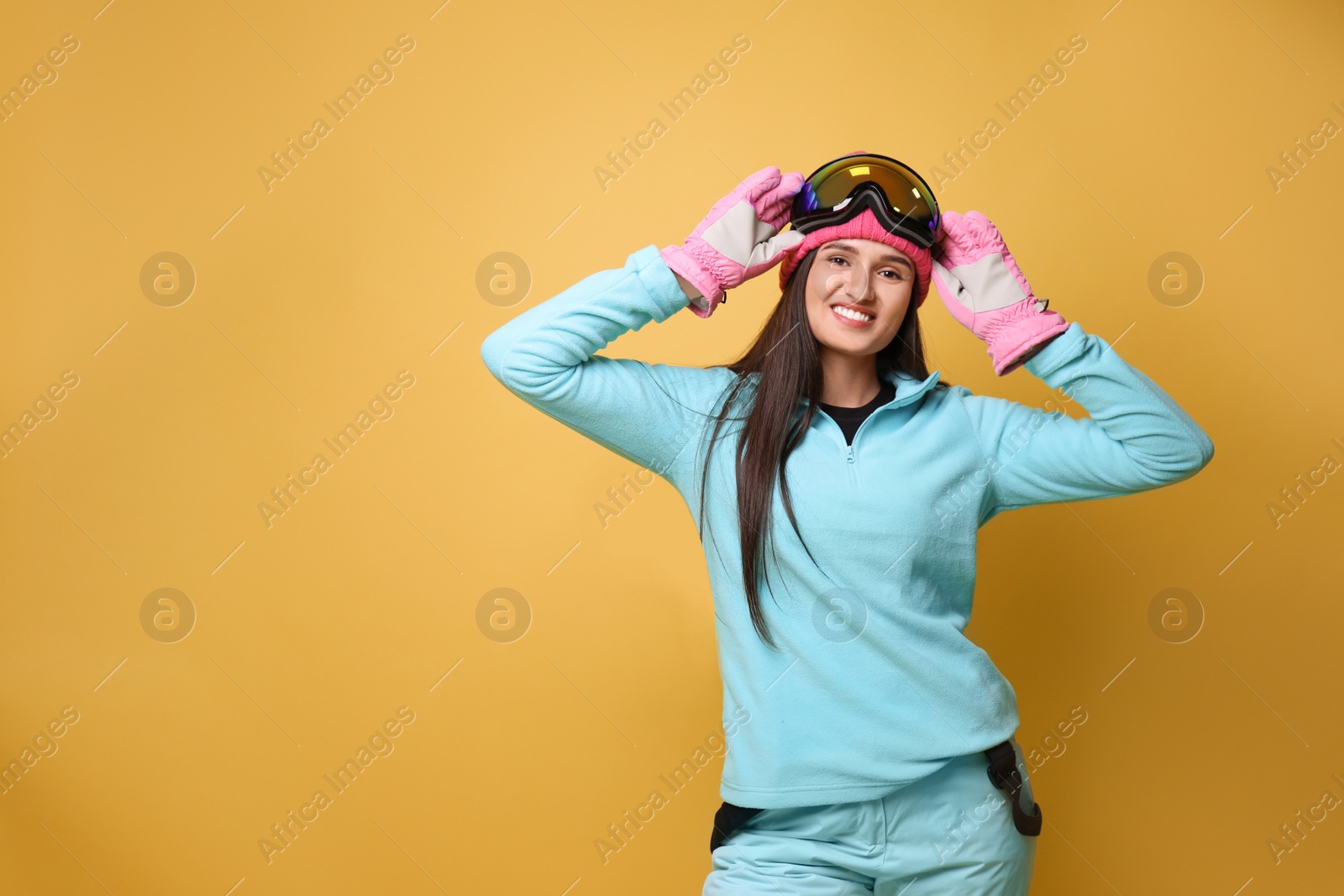 Photo of Woman wearing stylish winter sport clothes on yellow background