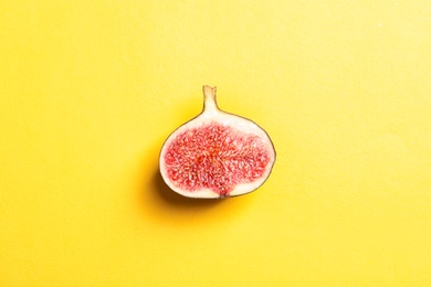 Photo of Half of ripe fig on color background, top view