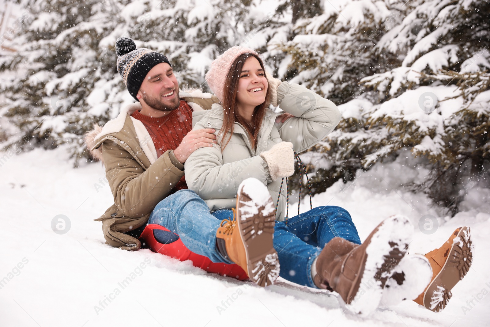 Photo of Couple having fun outdoors on snowy day. Winter vacation