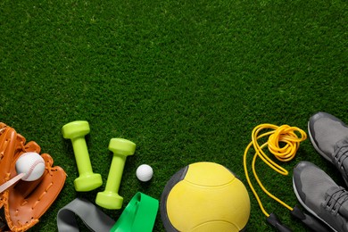 Photo of Different sport tools on green grass, flat lay. Space for text