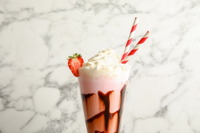 Photo of Glass with delicious milk shake on marble background, closeup