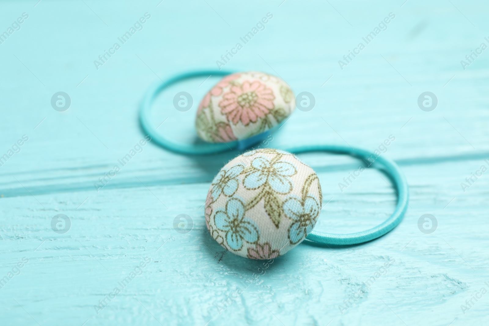 Photo of Cute hair scrunchies on light blue wooden table