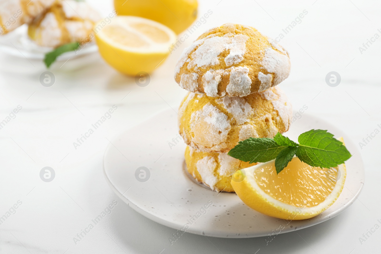 Photo of Tasty homemade lemon cookies with fresh fruit and mint on white marble table, space for text