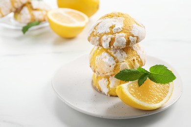 Photo of Tasty homemade lemon cookies with fresh fruit and mint on white marble table, space for text