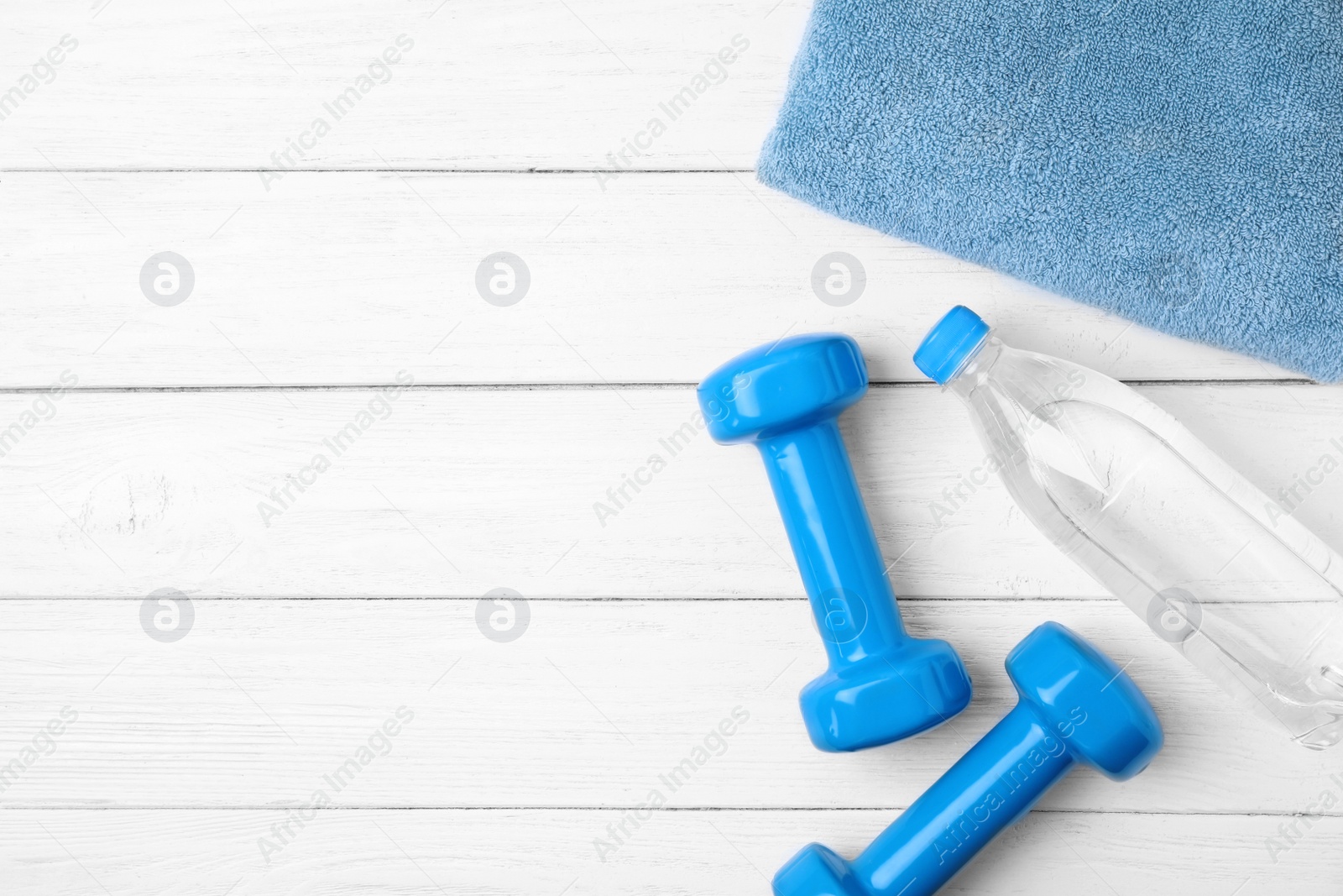 Photo of Flat lay composition with dumbbells and space for text on wooden background. Home fitness