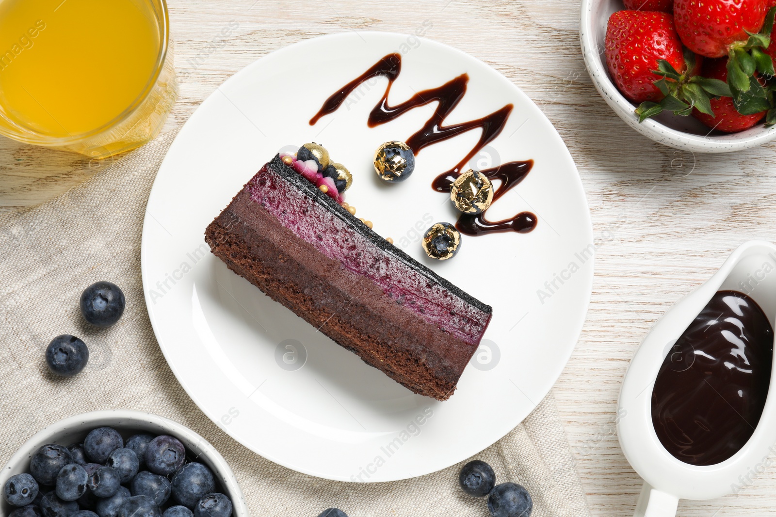 Photo of Delicious cake with blueberry and strawberries on white wooden table, flat lay