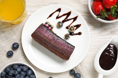 Photo of Delicious cake with blueberry and strawberries on white wooden table, flat lay