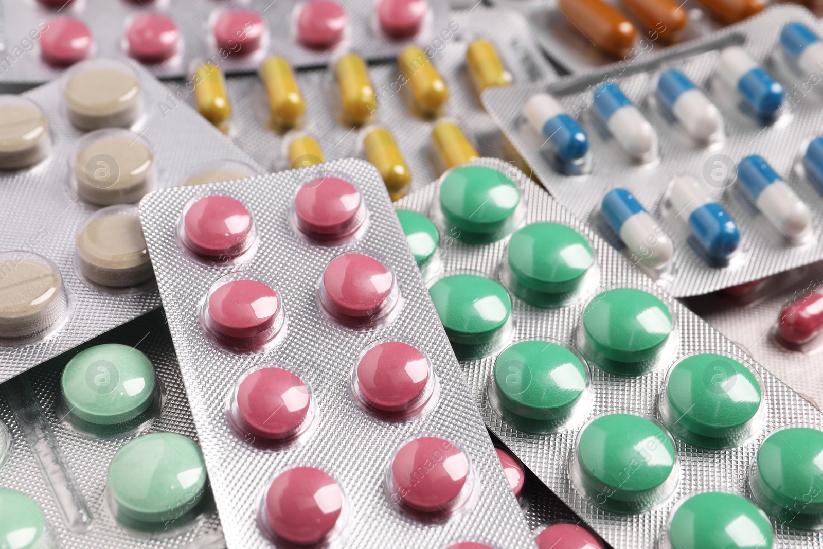 Photo of Many different pills in blisters as background, closeup