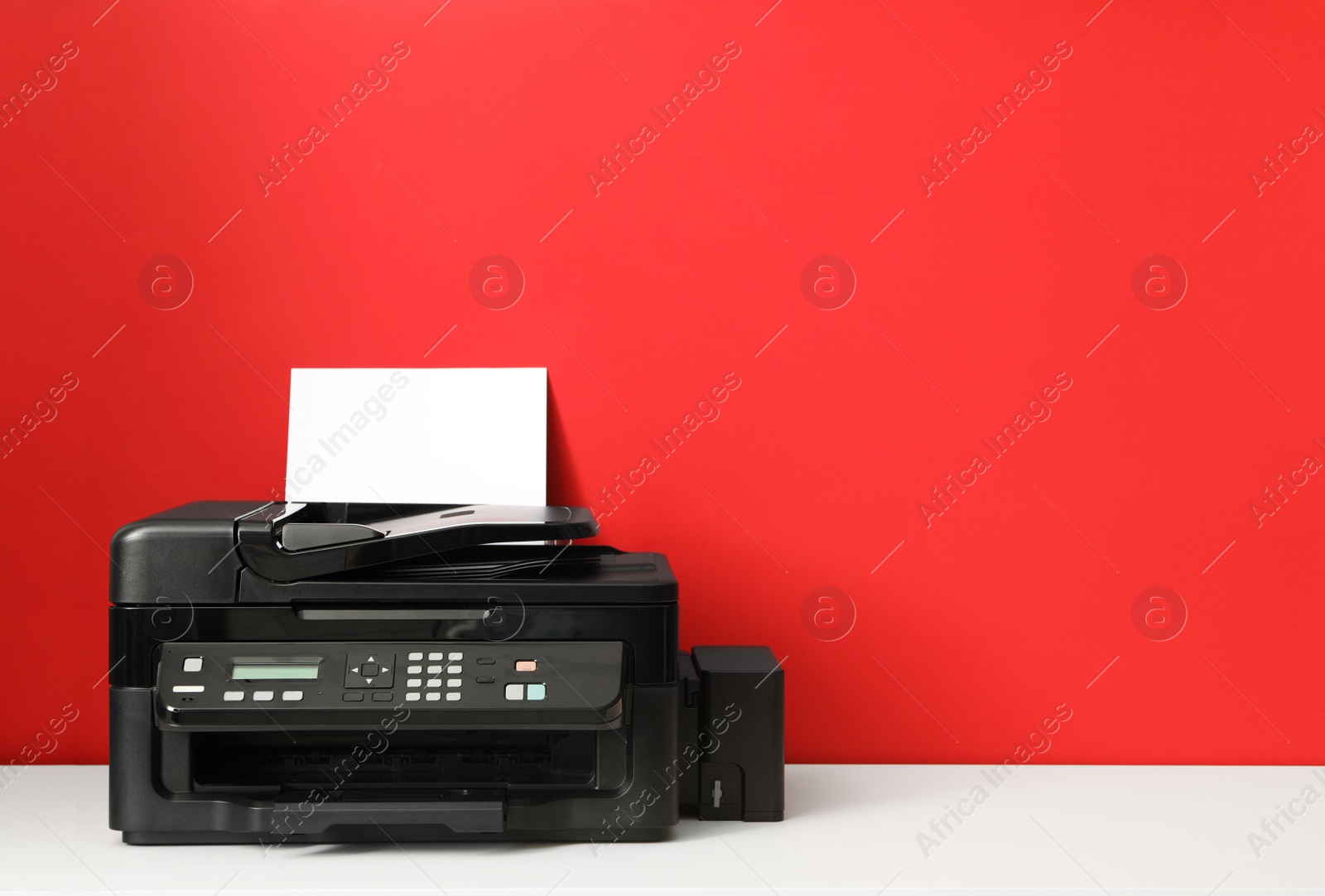 Photo of Modern printer with paper on red background. Space for text