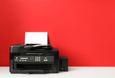 Photo of Modern printer with paper on red background. Space for text