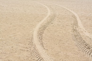 Photo of Sandy beach with tire tracks as background