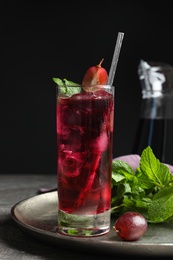 Photo of Delicious grape soda water with mint on grey table. Refreshing drink