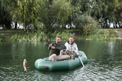Photo of Friends fishing from boat on river. Recreational activity