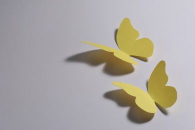 Photo of Yellow paper butterflies on light background. Space for text
