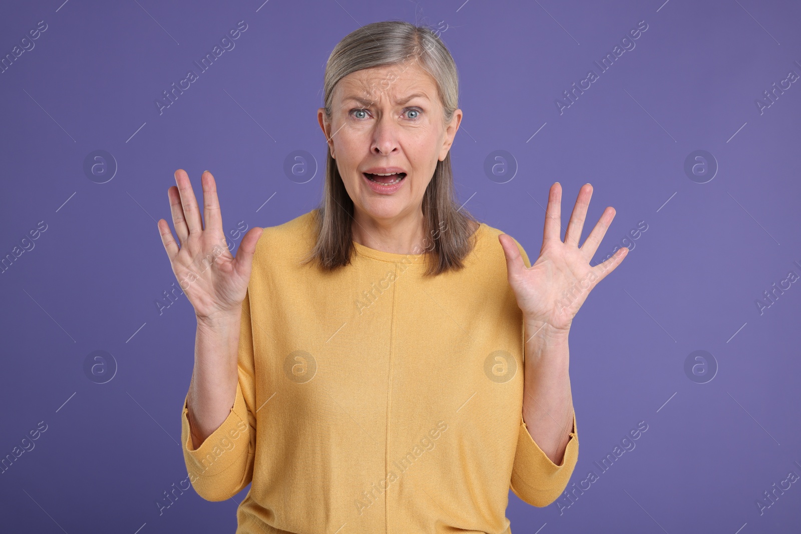 Photo of Portrait of surprised senior woman on violet background