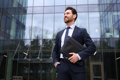 Photo of Real estate agent with leather portfolio outdoors. Space for text